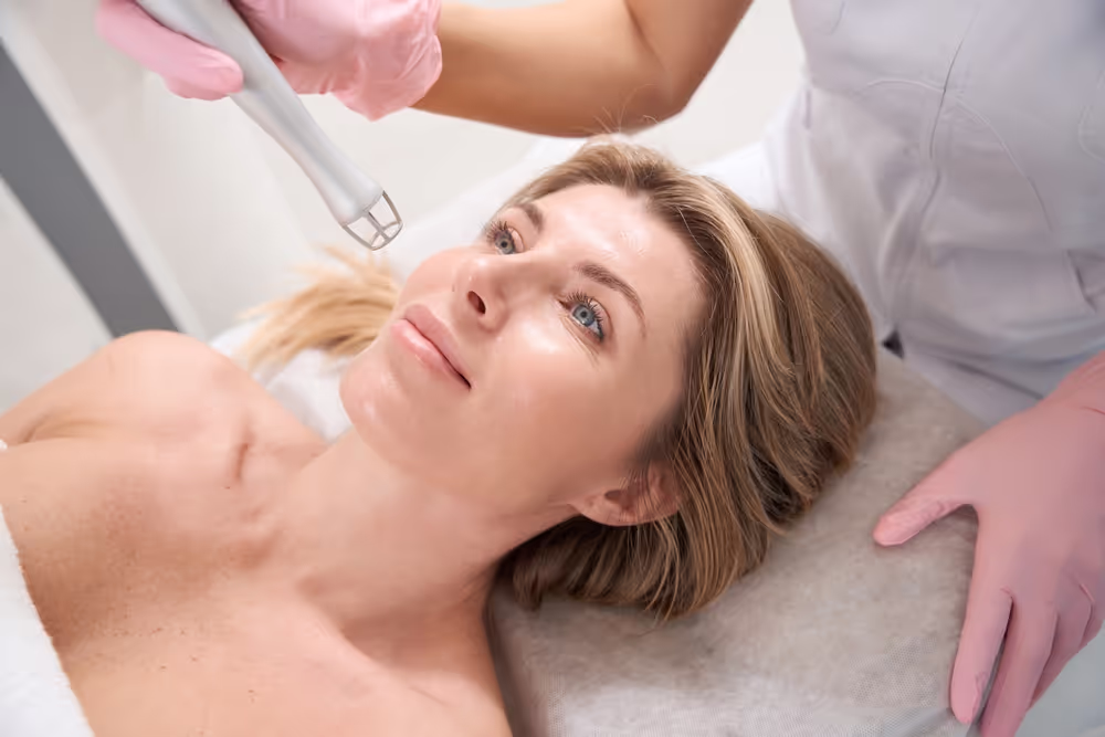 Woman receiving facial treatment in clinic