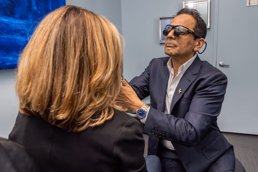 Médico examinando el rostro del paciente con gafas puestas